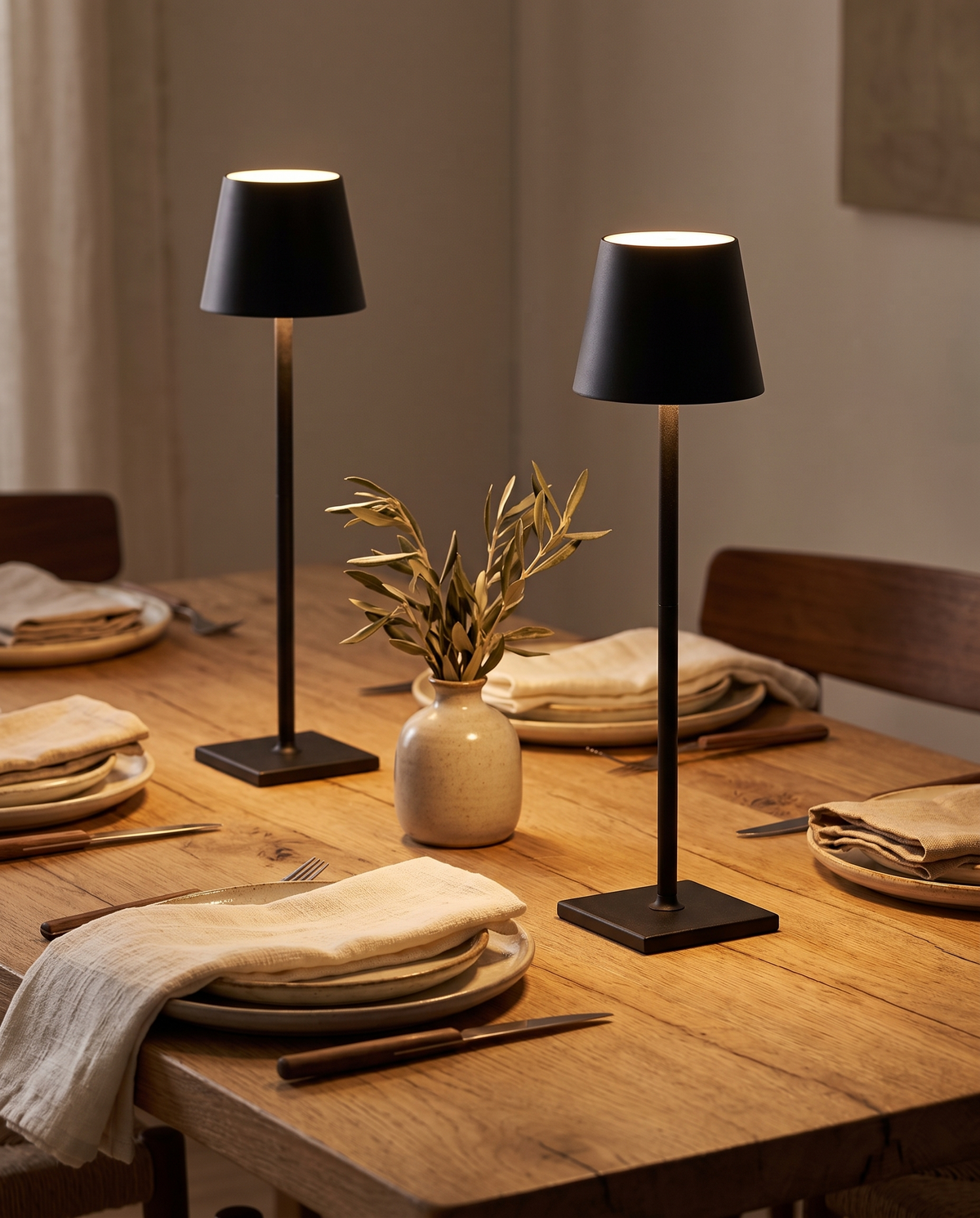 Two cordless table lamps on an oak dining table set for dinner, Wick & Wool