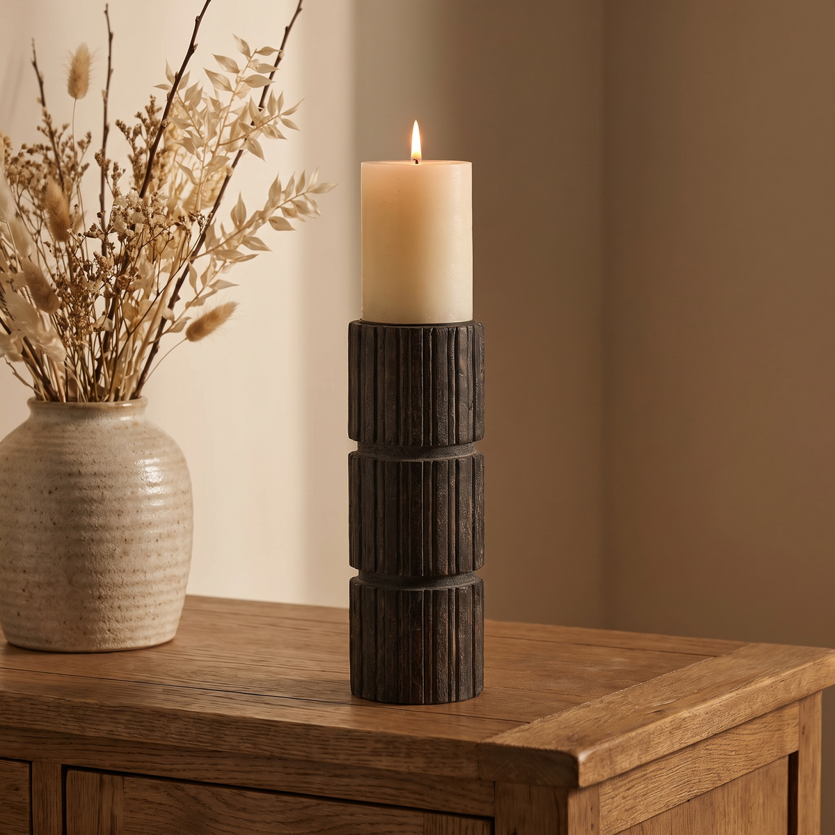Carved wooden pillar candle holder on an oak sideboard, Wick & Wool