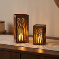 Two wooden tree lanterns glowing on a walnut sideboard