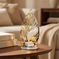 Gold leaf tealight holder with a lit tealight on a walnut side table