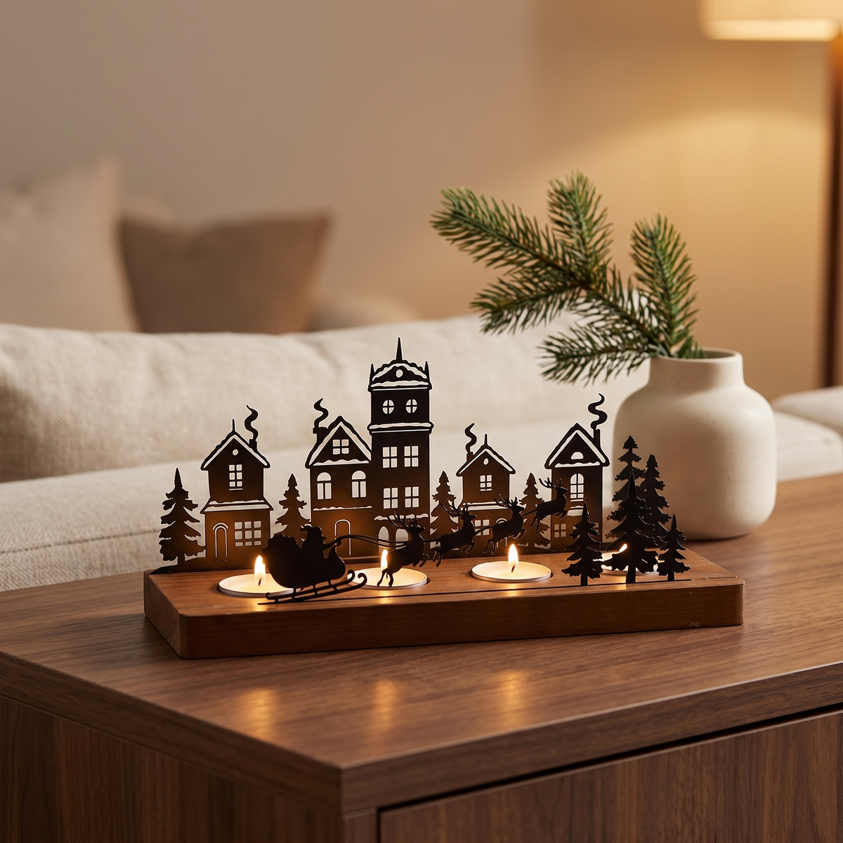Christmas village tealight holder with Santa's sleigh, tealights lit on a walnut table